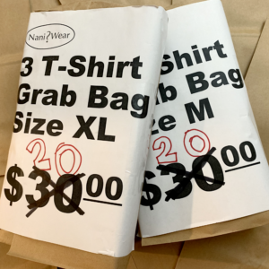 Image of 2 NaniWear grab bags. One with t-shirt size of extra-large and one with t-shirt size medium. Price is 30 dollars, but it's crossed out and a marker has 20 dollars instead. Wrapped in a brown paper bag.