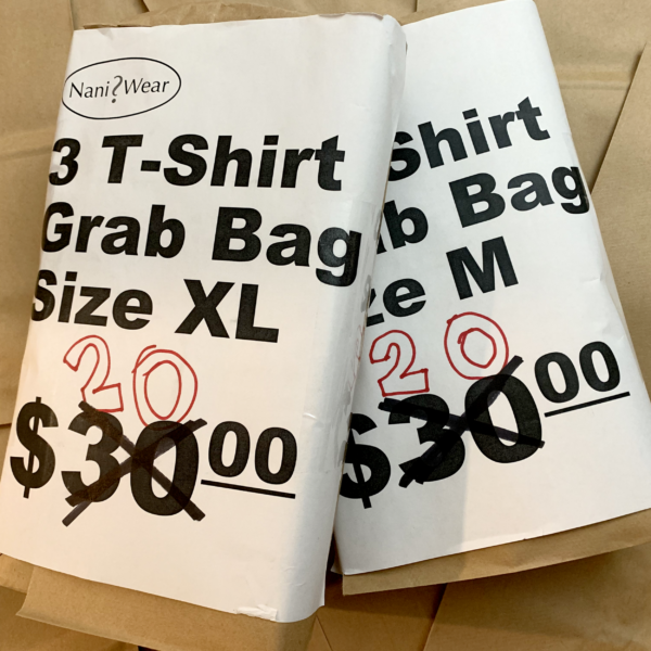 Image of 2 NaniWear grab bags. One with t-shirt size of extra-large and one with t-shirt size medium. Price is 30 dollars, but it's crossed out and a marker has 20 dollars instead. Wrapped in a brown paper bag.
